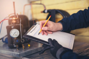 Technician Filling Out Ac Maintenance Checklist