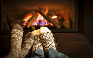 People In Fuzzy Socks Warming Their Feet By The Fireplace